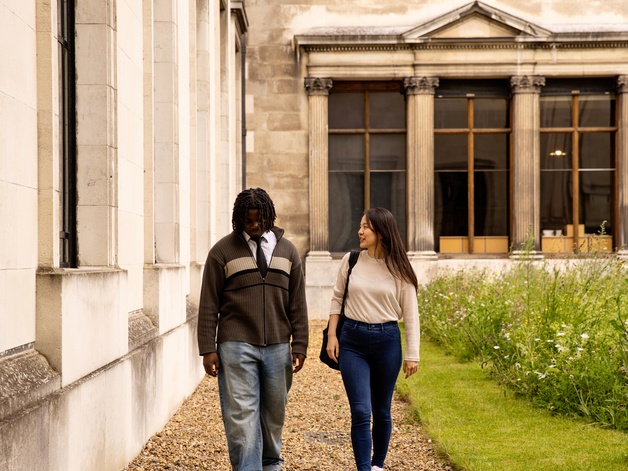 Two students walking outside a building