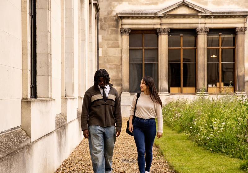 Two students walking outside a building